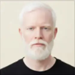Serious man with white hair and beard wearing a black shirt, symbolizing wisdom and trust in holistic health at Dr. Jyoti Dharmdas Homeo Clinic, Bhopal, led by Dr. Renu Rajput Barigal – the best homeopathy doctor in Bhopal.